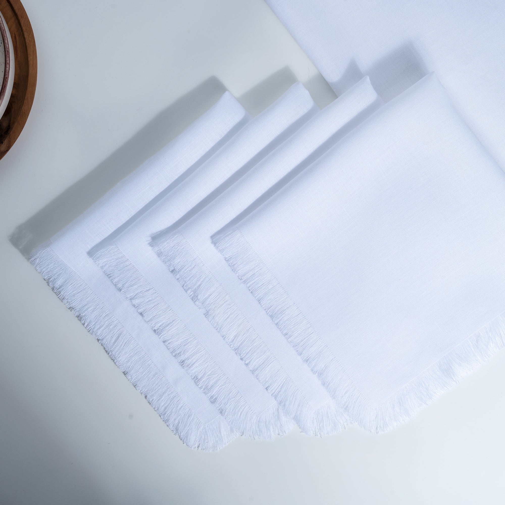Close-up of the fringed edge on white pure linen dinner napkins
