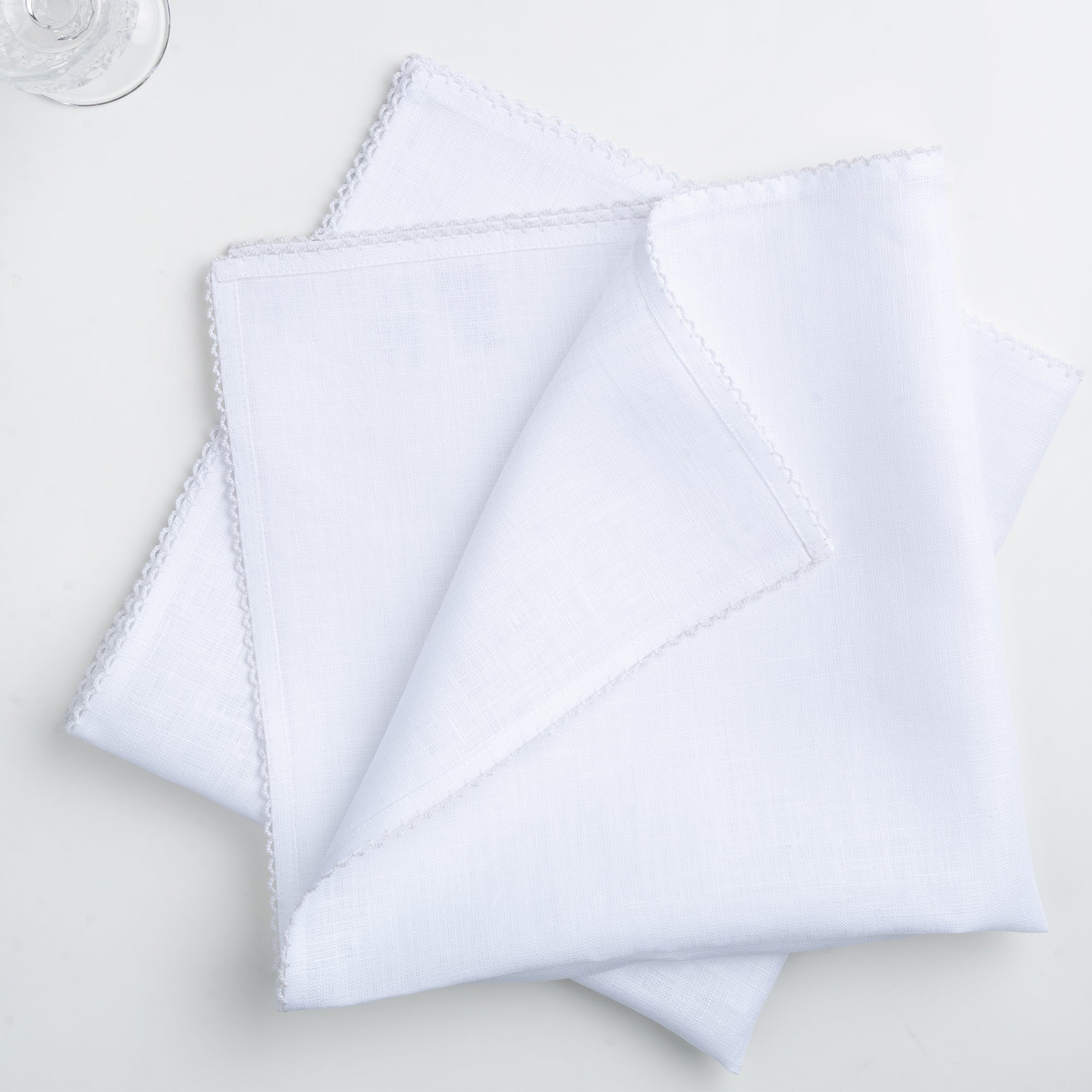 White and white pure linen dinner napkins styled on a dining table
