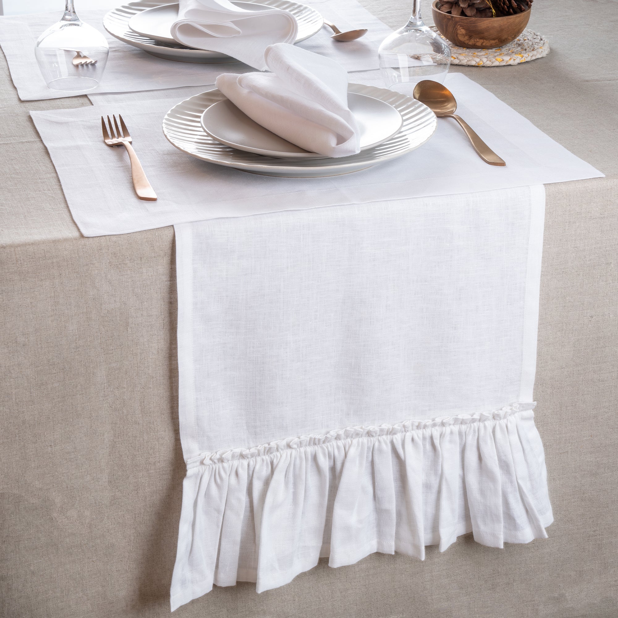 Close-up of the ruffled edge on a white pure linen table runner