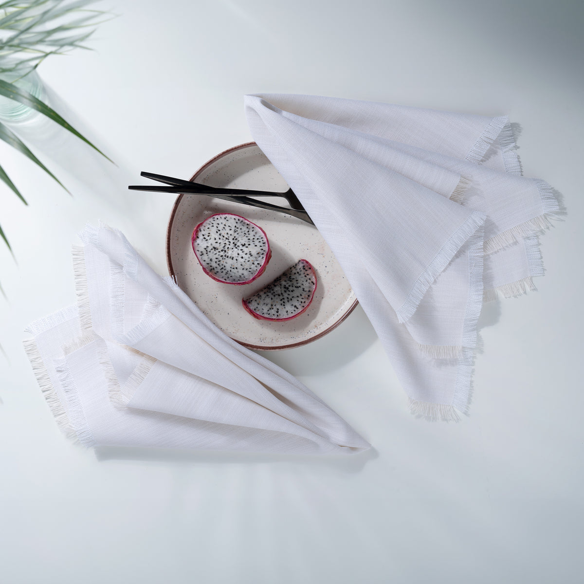 Close-up of the fringed edge on chambray cream and white faux linen dinner napkins