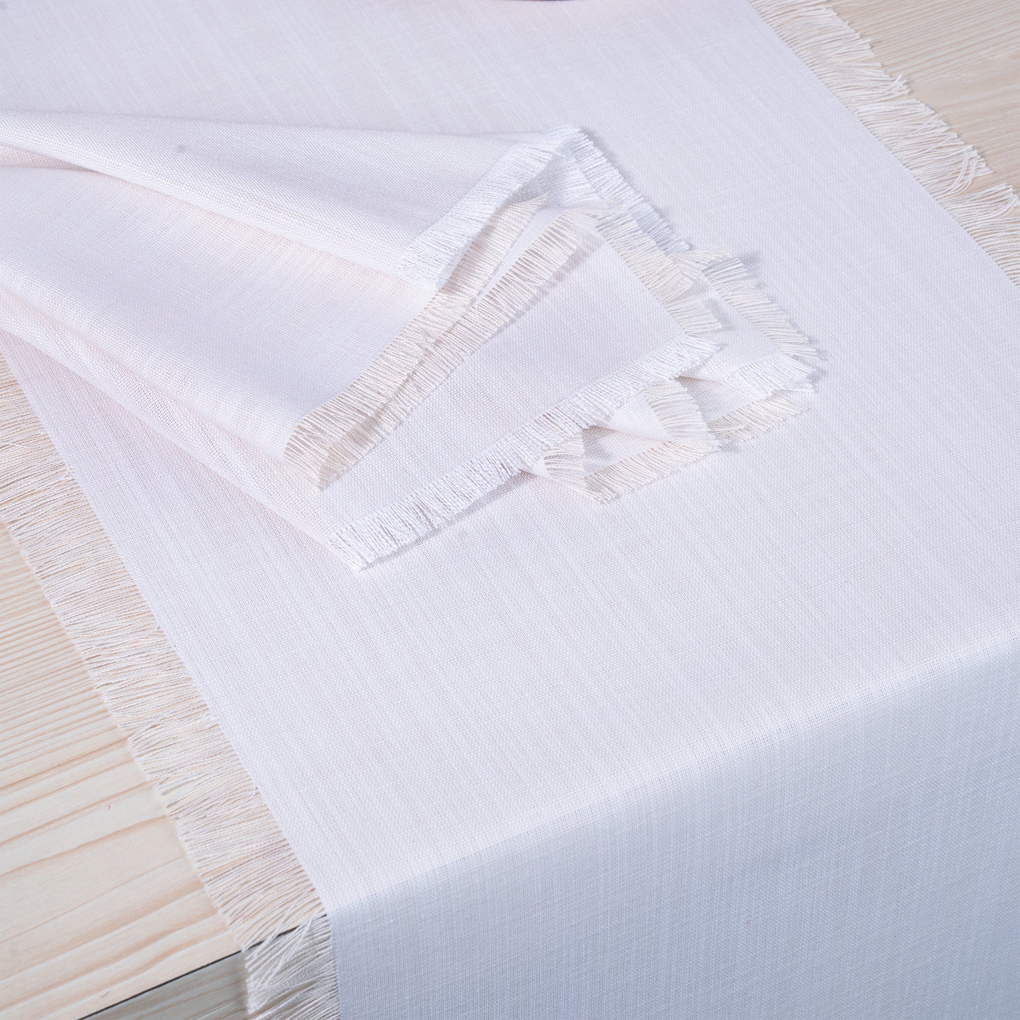 Close-up of the fringed edge on a chambray cream and white faux linen table runner